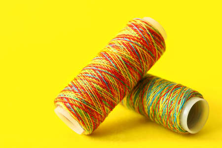 Rainbow sewing thread spools on color backgroundの写真素材