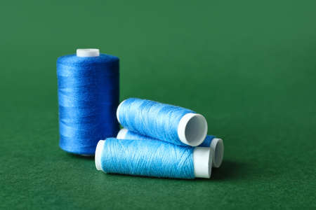 Blue sewing thread spools on color backgroundの写真素材
