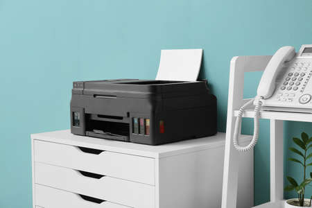 Chest of drawers with modern printer and shelf unit near color wall, closeupの写真素材