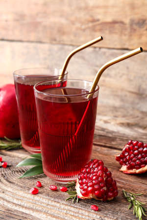 Glasses of delicious pomegranate juice on wooden backgroundの写真素材