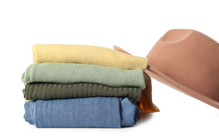 Stack of different stylish clothes and felt hat on white background, closeup
