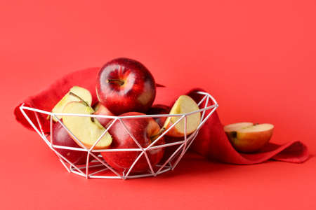 Basket with fresh apples on color backgroundの写真素材