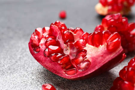Piece of fresh pomegranate on gray background, closeupの写真素材