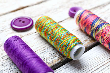 Sewing threads on light wooden background, closeupの写真素材