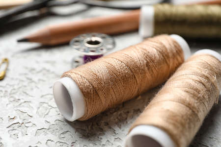 Sewing threads on light background, closeup