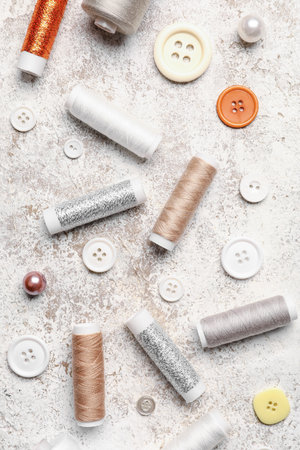 Sewing threads with buttons on light background