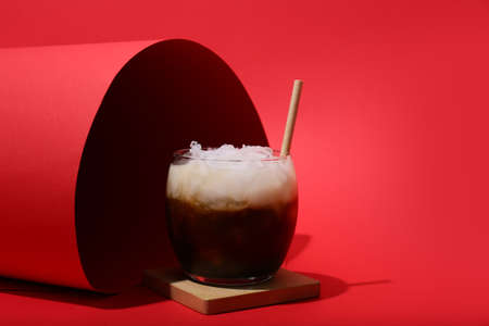 Glass of White Russian cocktail on red backgroundの写真素材