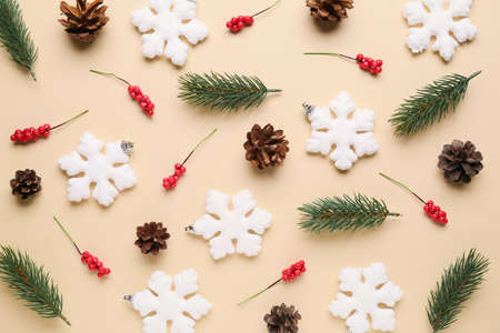 Composition with snowflakes, fir branches and berries on yellow background