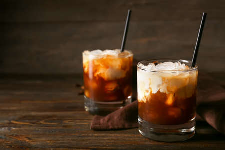 Glasses of White Russian cocktail on wooden background