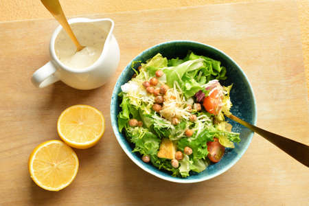 Bowl of tasty vegan Caesar salad on beige backgroundの写真素材