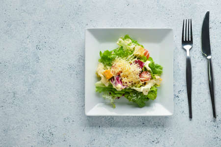 Plate of tasty vegan Caesar salad on light background