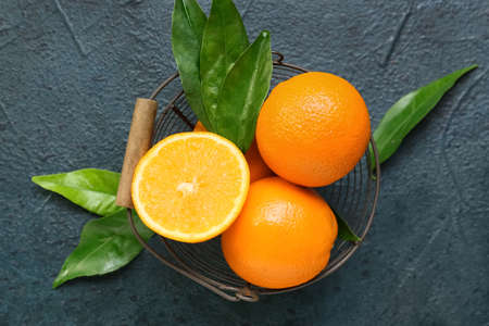 Basket with fresh juicy oranges on black background