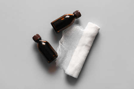 Bottles with iodine and gauze roll on gray backgroundの写真素材