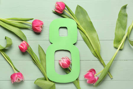 Composition with beautiful flowers for International Women's Day on color wooden background