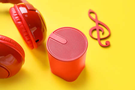 Wireless portable speaker, headphones and treble clef on yellow background, closeupの写真素材