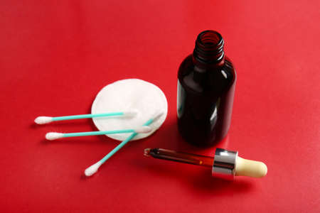 Bottle with iodine, cotton pad and swabs on red backgroundの写真素材