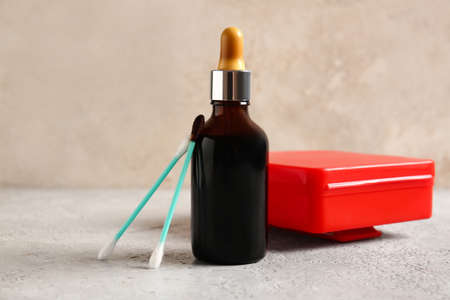 Bottle with iodine, cotton swabs and first aid kit on grunge backgroundの写真素材