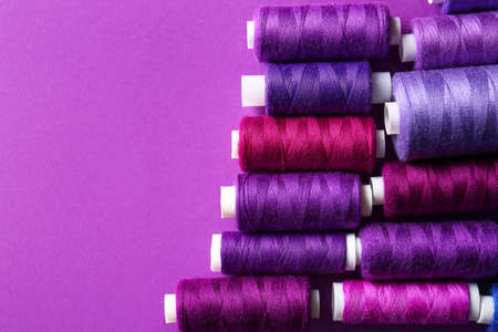 Spools with sewing threads on purple backgroundの写真素材