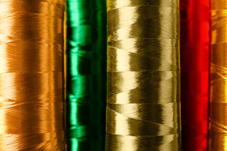 Spools with silk sewing threads as background, closeup