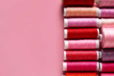 Different spools with sewing threads on color backgroundの写真素材
