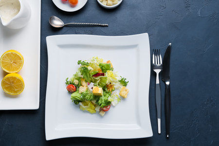 Plate with tasty vegan Caesar salad on dark backgroundの写真素材