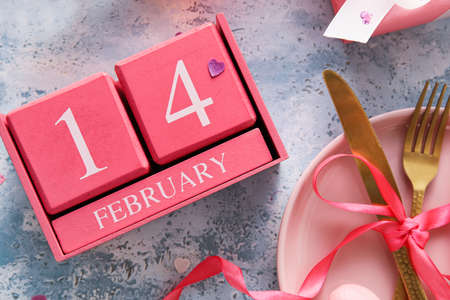 Calendar with date of Valentines Day and table setting on blue backgroundの写真素材