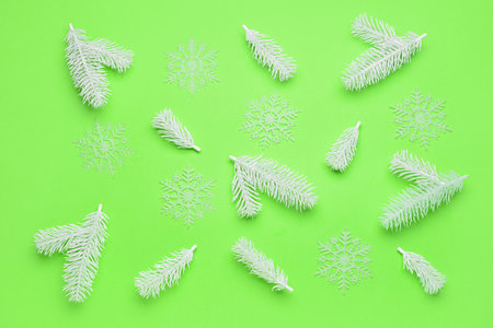 Snowflakes and fir tree branches on green background