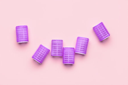 Purple hair curlers on pink backgroundの写真素材