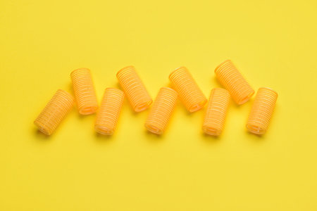 Hair curlers on yellow backgroundの写真素材