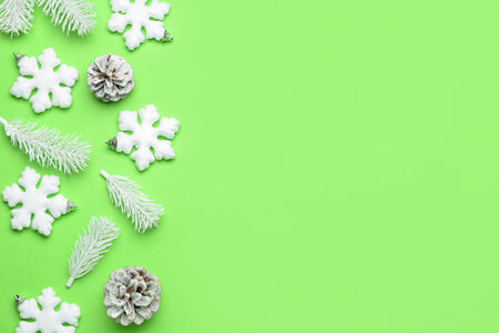 Composition with snowflakes, fir tree branches and pine cones on green backgroundの写真素材