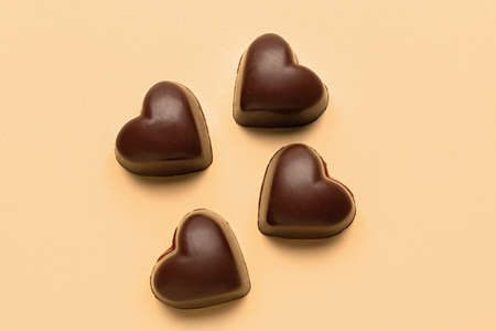 Tasty heart-shaped candies on beige background
