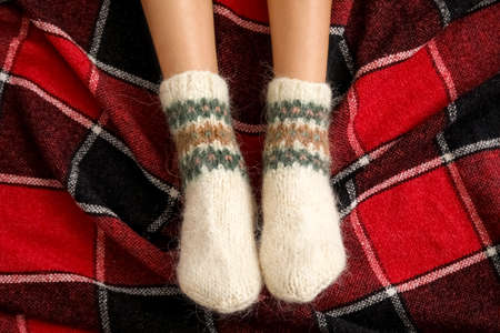 Female legs in warm knitted socks on plain. Concept of heating seasonの写真素材