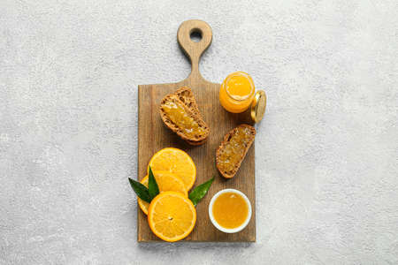 Tasty orange jam and bread on light backgroundの写真素材
