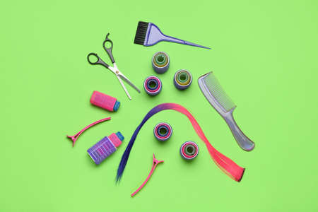Composition with hairdresser's tools, hair strand and curlers on green backgroundの写真素材