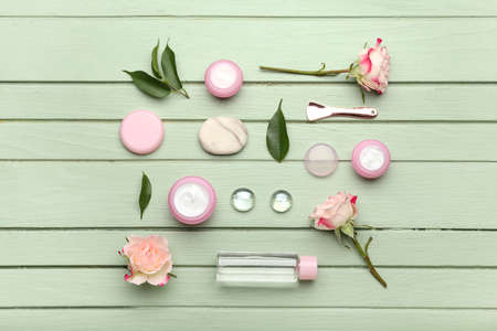 Composition with jars of natural cosmetic cream and flowers on color wooden backgroundの写真素材