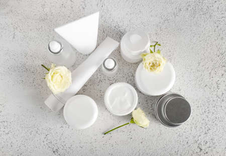 Different cosmetic products and flowers on light backgroundの写真素材