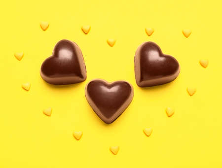 Tasty heart-shaped candies on yellow backgroundの写真素材