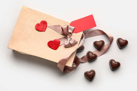 Tasty heart-shaped candies and package on white backgroundの写真素材