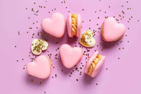 Tasty heart-shaped macaroons an confetti on purple backgroundの写真素材