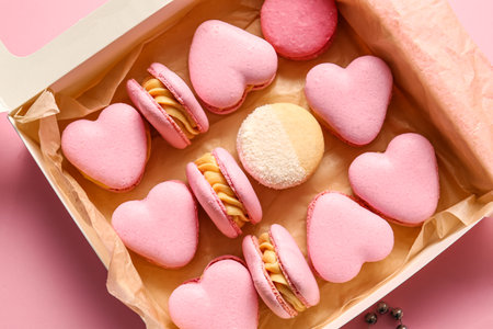 Box with tasty heart-shaped macaroons on pink background, closeupの写真素材