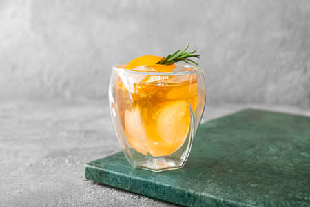 Glass of delicious Old Fashioned Cocktail on gray backgroundの写真素材