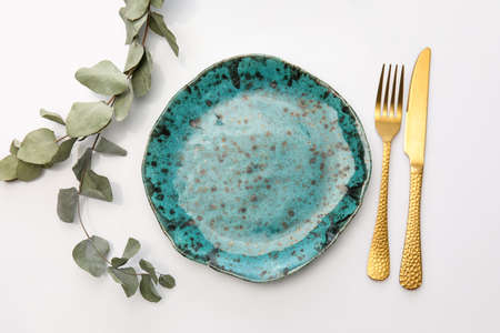 Elegant table setting with eucalyptus leaves on white background