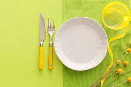 Elegant table setting with flowers on green background