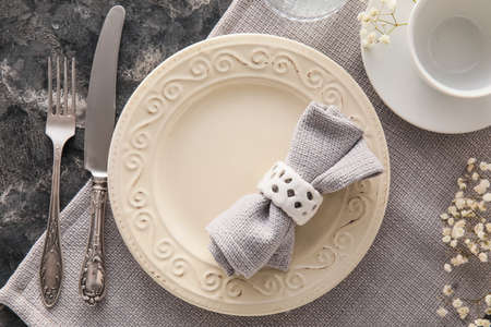Elegant table setting with flowers on dark grunge background