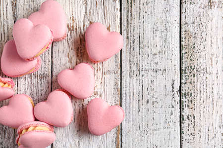 Tasty heart-shaped macaroons on white wooden backgroundの写真素材