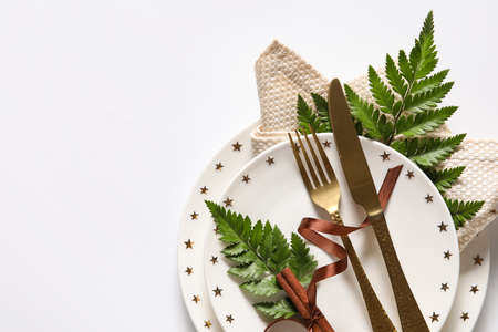 Stylish simple table setting and cinnamon on white background