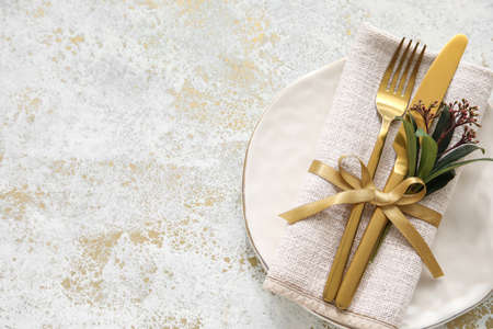 Stylish simple table setting and flowers on light backgroundの写真素材