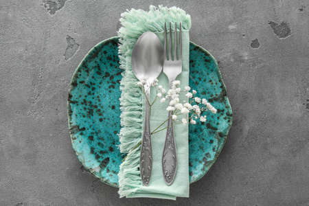 Simple table setting with flowers on gray background