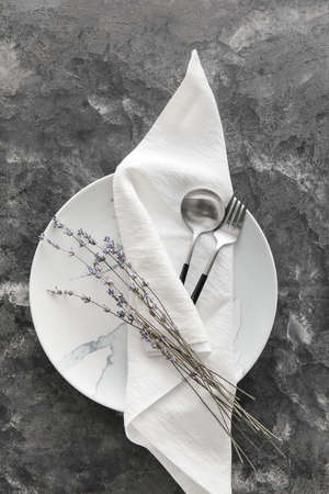 Beautiful table setting with flowers on dark grunge background