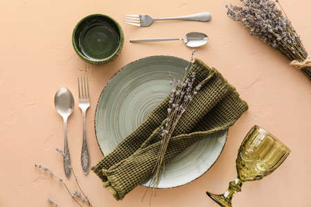 Beautiful table setting with lavender flowers on beige backgroundの写真素材